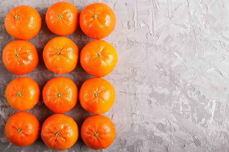 Rows of tangerines forming a rectangle on a gray concrete background, top view, flat lay. copy space