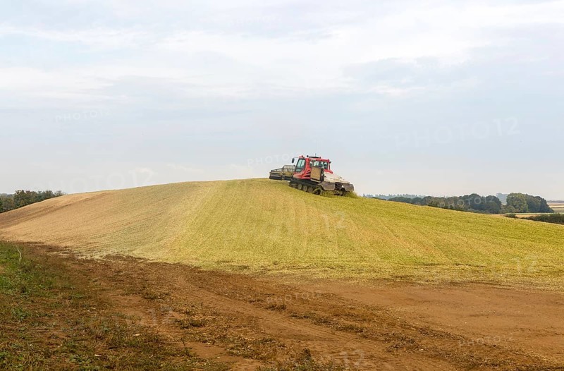 Piston Bully tracked bulldozer vehicle building silage clamp of sweetcorn maize in field stored for biofuel, Alderton, Suffolk, England, UK