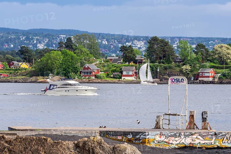 Pleasure boats passing the museum island Bygdøy, view to east side of Oslofjord, ferry stop for local ferries connecting Bygdøy with center of Oslo, Oslo, Norway, Europe