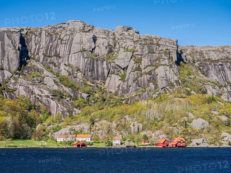 Steep granite mountains at the sea near Ana Sira, village Stornes, typcial coastal village, at coastal road 44 between Kristiansand and Egersund, southern Norway