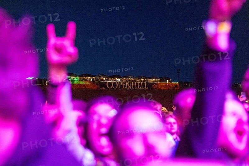 Copenhagen, Denmark - 19.6.2024: Festivalgoers with hands shaped like French fries in front of the logo at the Copenhell Metal Festival at Kløverparken Camping Copenhagen, Denmark. The festival takes place from 19-22 June 2024