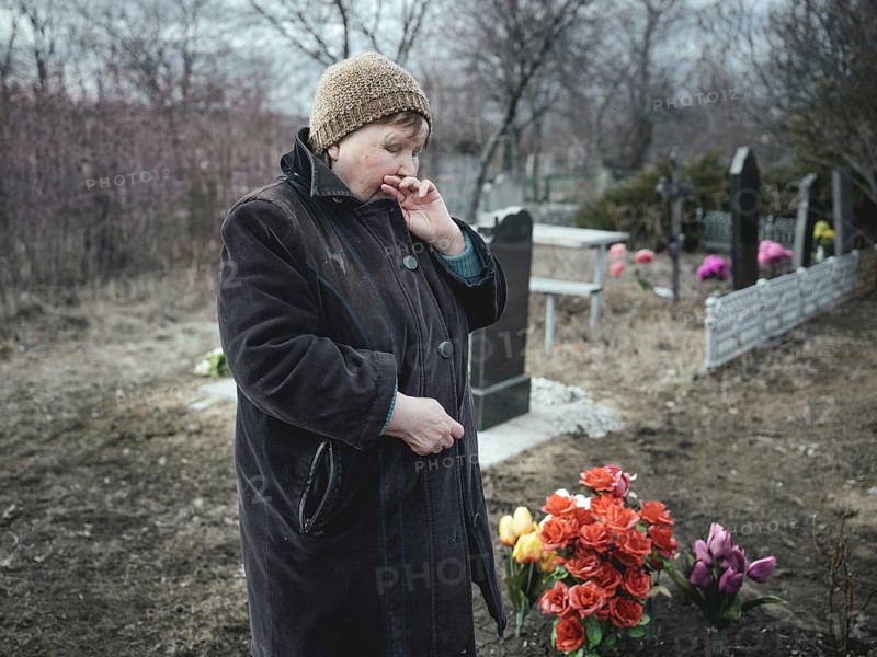 Ludmilla (68) mourns her grandson, who died at the front a month earlier, at the cemetery. The parents have not left the house since and have given in to alcohol, Spodovivka, Ukraine, Europe