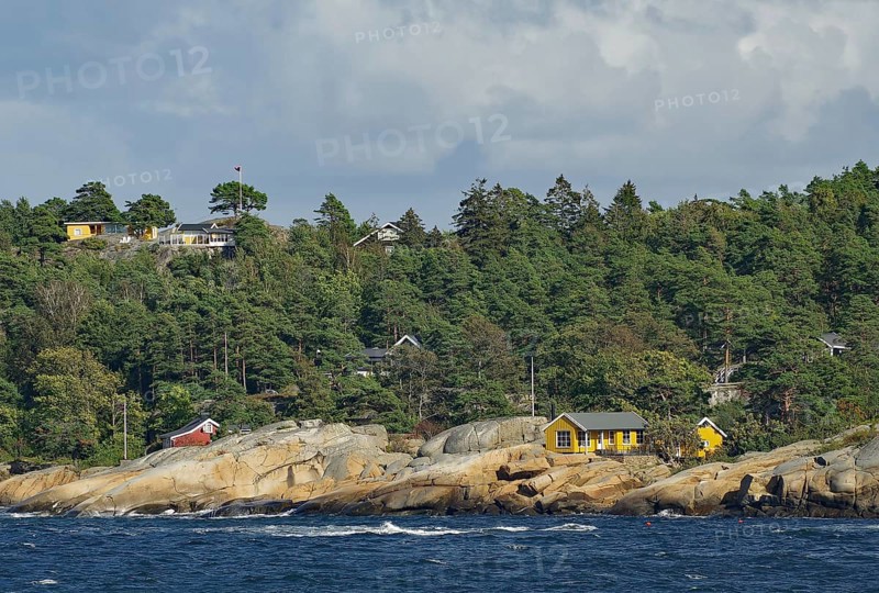 Coastal landscape with rocks, several houses and forest under a cloudy sky, Holiday homes, Archipelago, Sandefjord, Norway, Europe