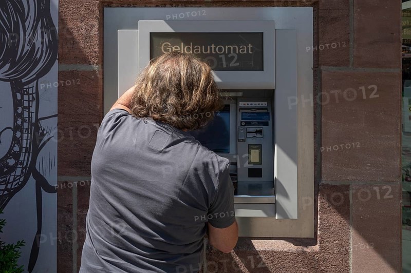 Man withdrawing money from an ATM, Nuremberg, Middle Franconia, Nuremberg, Germany, Europe