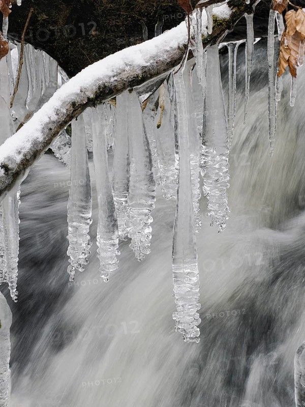 Icicles on the hill stream the Schwartzbach, in snow and ice in November. The Rhön UNESCO Biosphere nature reserve, county Bavari, Germany, Europe