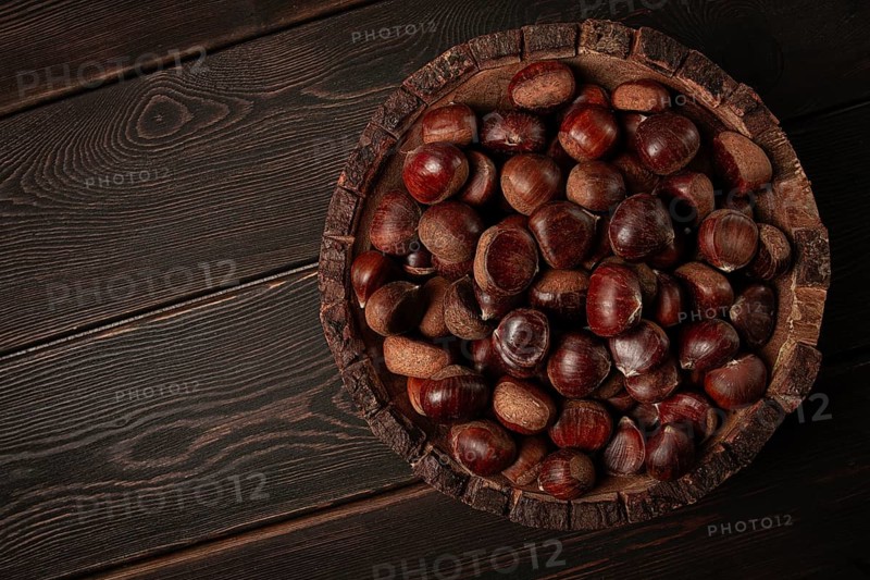 Fresh chestnuts, in a wooden bowl, top view, no people