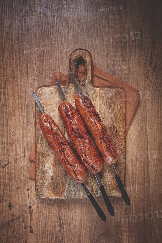 Fried sausages, in English with bacon, for grilling, on a cutting board, top view, no people