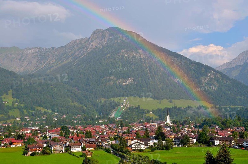 View over Oberstdorf with rainbow, behind it the Schattenberg with Schattenbergschanze, Oberallgäu, Bavaria, Germany, Europe