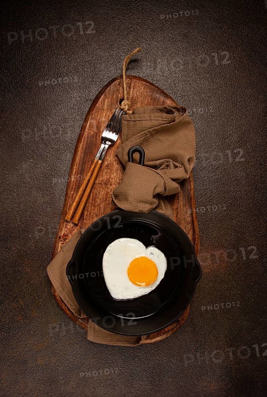 Fried egg in a cast-iron pan, breakfast, fried eggs in the shape of a heart, top view, no people, homemade