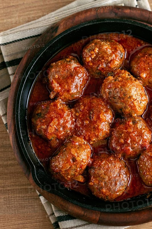 Minced meat meatballs, in tomato sauce, in a cast-iron pan, homemade, no people