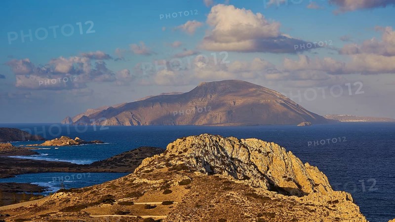 Coastal landscape with rock formations and an island in the background under clouds, Acropolis Hill, Arkasa, Kassos Island, West Coast, Karpathos, Dodecanese, Greek Islands, Greece, Europe