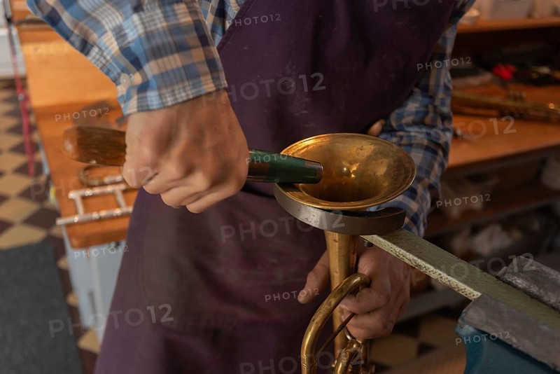 Metal instrument maker dents the bell of a trumpet, Magdeburg, Saxony-Anhalt, Germany, Europe