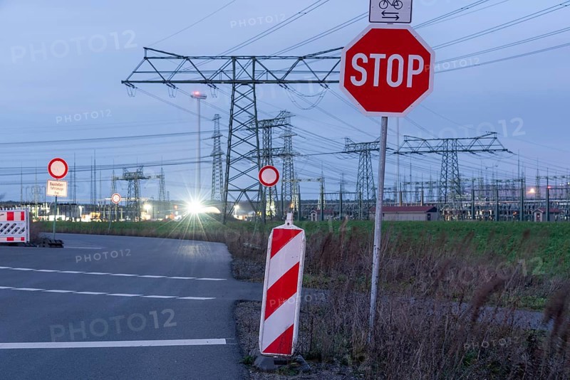 Road with stop sign and high-voltage pylons in the background, evening mood, Wolmirstedt, Saxony-Anhalt, Germany, Europe