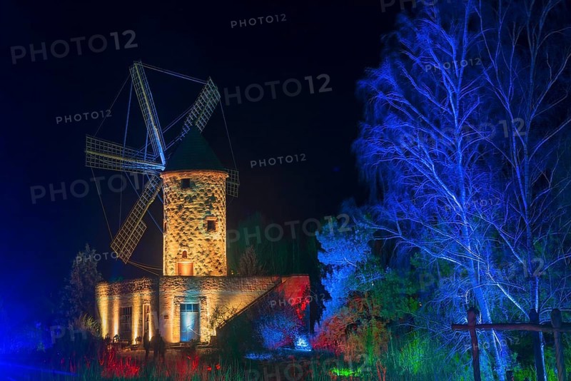 Historic stone mill at night, illuminated in blue, surrounded by trees, world of lights, illumination, mill museum, Gifhorn, Lower Saxony, Germany, Europe