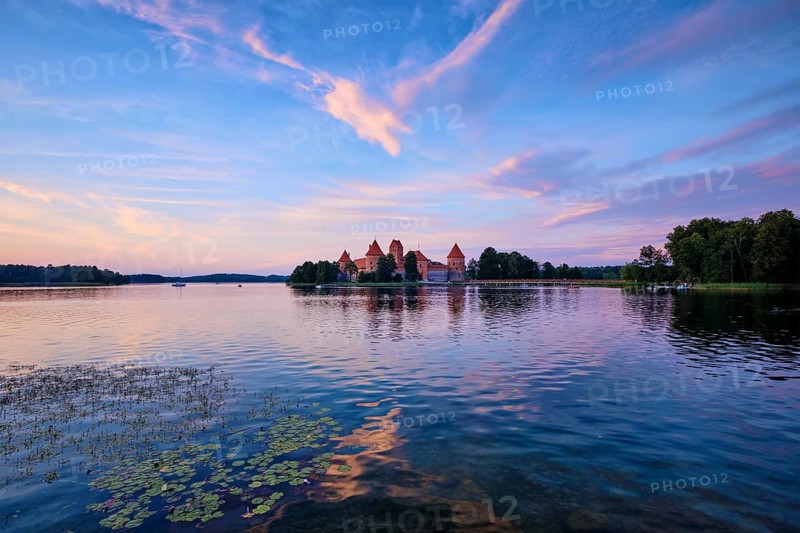 Trakai Island Castle in lake Galve, Lithuania on sunset with dramatic sky reflecting in water. Trakai Castle is one of major tourist attractions of Lituania