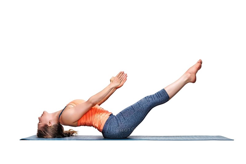 Beautiful sporty fit woman practices Ashtanga Vinyasa Yoga asana Uttana padasana, raised legs pose isolated on white