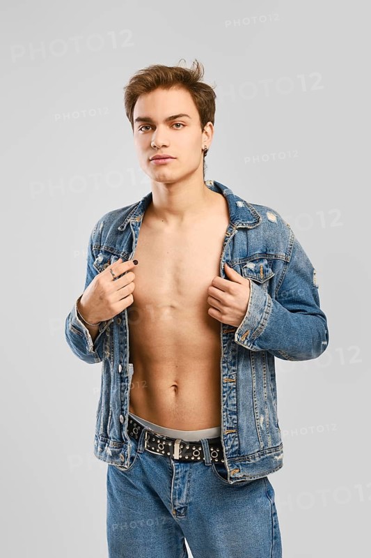 Young man in denim clothes ober naked body
