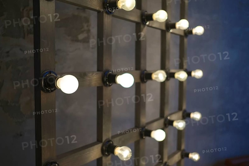 Old edison lamp mounted on wooden background