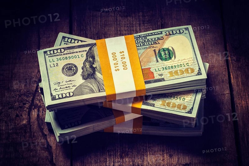 Creative business finance making money concept. Vintage retro effect filtered hipster style image of stacks of new 100 US dollars 2013 edition banknotes bills bundles isolated on wooden background