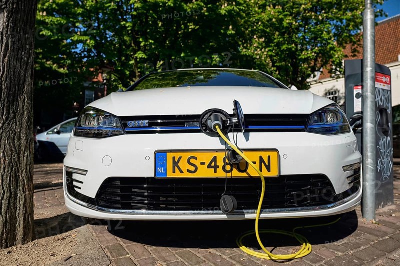 AMSTERDAM, NETHERLANDS, MAY 8, 2017: Volkswagen Golf GTE petrol-electric hybrid car being charged in the street
