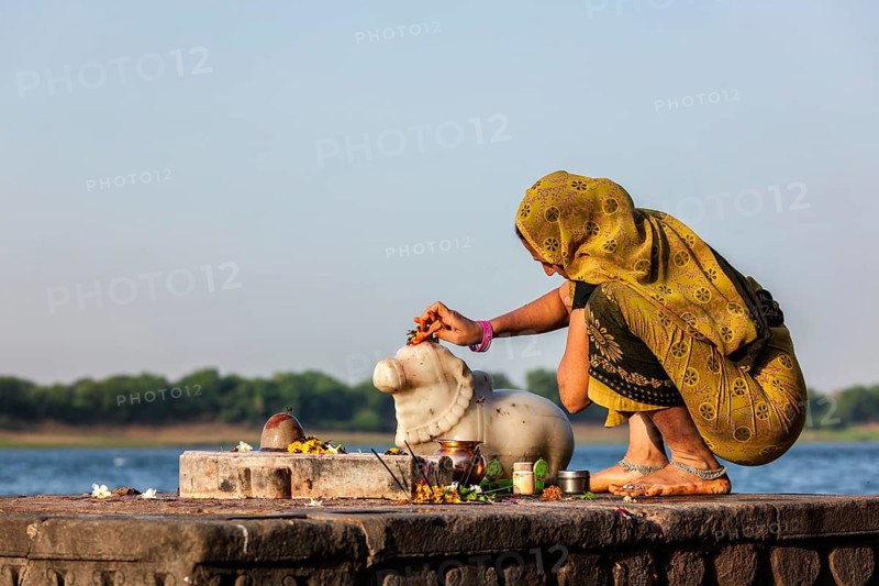 MAHESHWAR, INDIA, APRIL 26: Indian woman performs morning pooja on sacred river Narmada ghats on April 26, 2011 in Maheshwar, Madhya Pradesh, India. To Hindus Narmada is one of 5 holy rivers of India