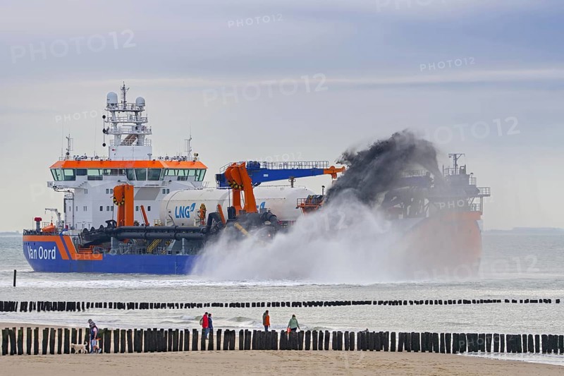 Trailing suction hopper dredger Vox Apolonia of Van Oord, Dutch maritime contracting company specialized in dredging, rainbowing along Zeeland coast
