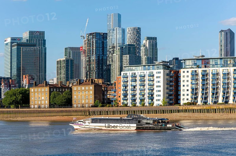 Uber boat water bus service passing Canary Wharf, Isle of Dogs, London, England, UK