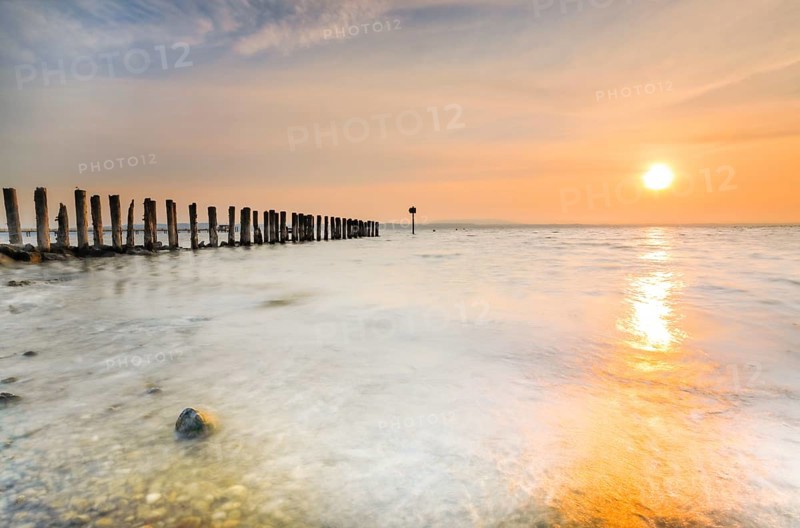 Golden sunrise on the shore of Lake Constance with jetty near Altnau in the canton of Thurgau, Switzerland, Europe