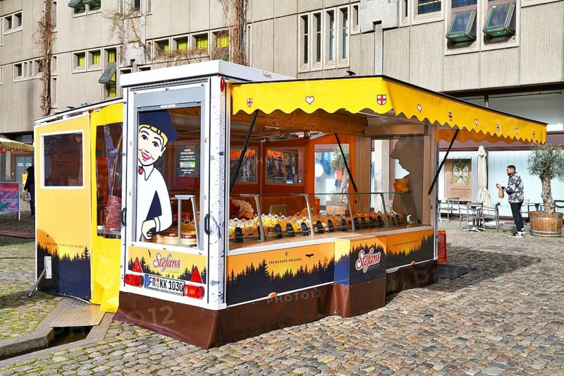 Freiburg, Germany, April 2022: Food truck called 'Stefan's Käsekuchen' selling traditional German cheesecake at daily market at Munster town square, Europe