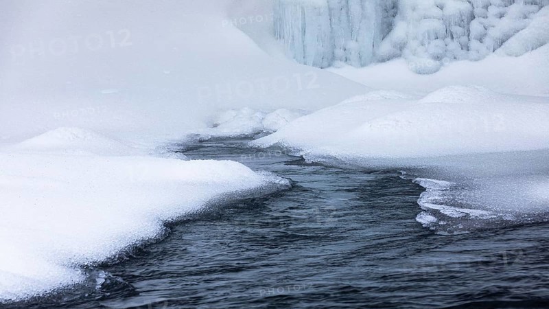 Snow mounds and icicles in the Skoga River below Skogafoss waterfall, Sudurland, Iceland, Europe