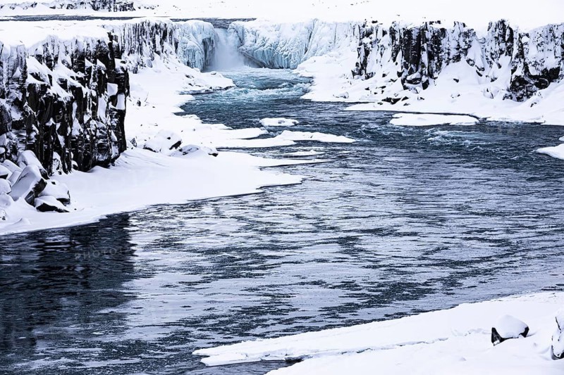 Selfoss waterfall with the river Jökullsa a Fjöllum, icy and snow-covered cliffs and shoreline, Northern Iceland Eyestra, Iceland, Europe
