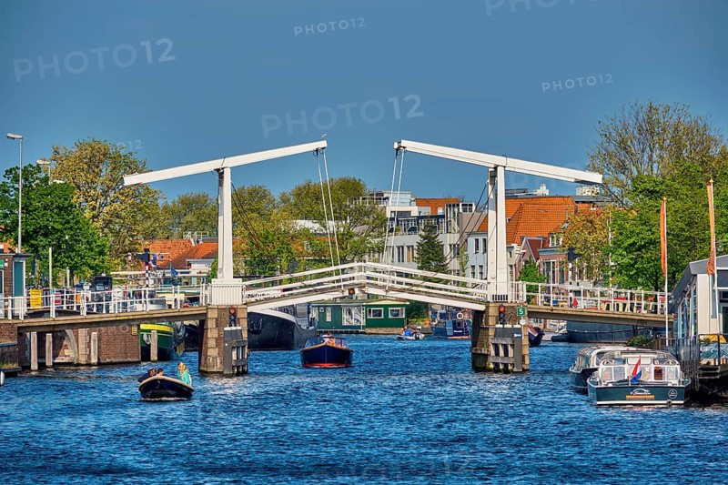 HAARLEM, NETHERLANDS, MAY 6, 2017: Boat passing under Gravestenenbrug bridge famous tourist landmark on Spaarne river in Haarlem, Netherlands