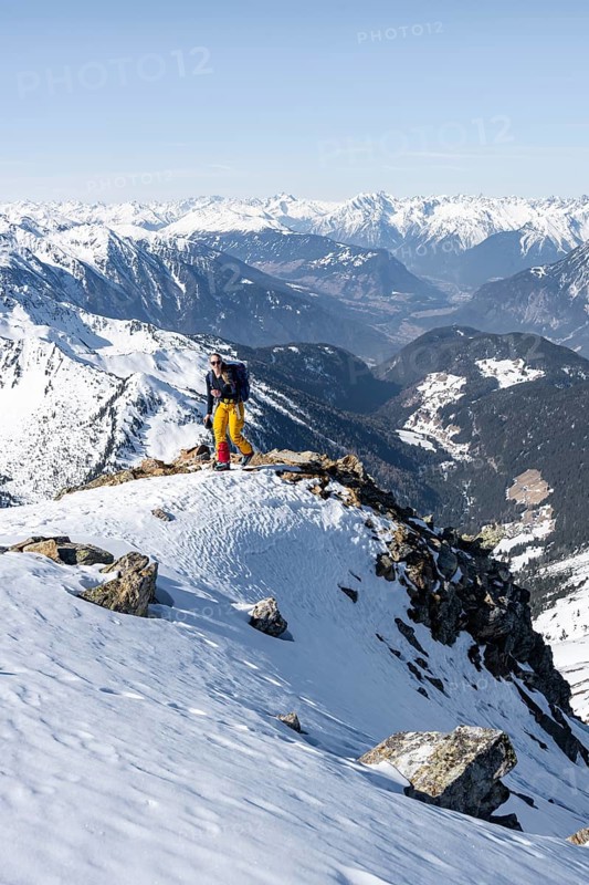 View of the Inn Valley, mountaineer at the summit of the Pirchkogel, mountains in winter, Sellraintal, Kühtai, Tyrol, Austria, Europe