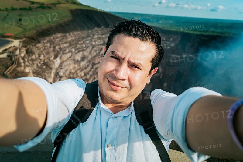 Adventurous people taking a selfie at a viewpoint. Close up of person taking an adventure selfie, Tourist taking a selfie at a viewpoint. Handsome tourist taking a selfie on vacation