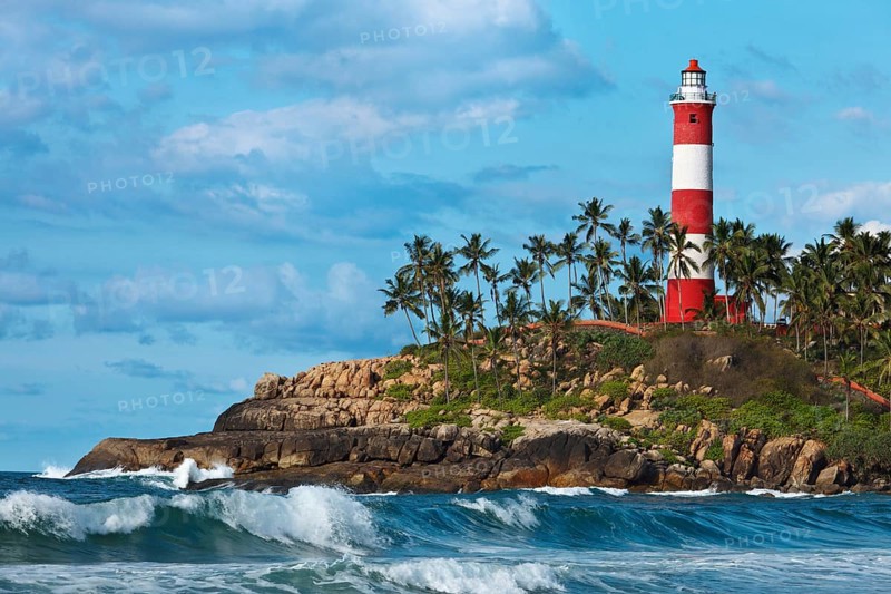 Lighthouse on rocky cliff and sea with waves