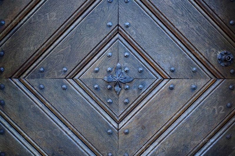 Detail of an old wooden door with traditional metal door knob