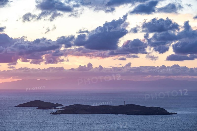 Nisos Gaidaros island with lighthouse in the sea at sunrise with dramatic clouds, Ermoupoli, Syros, Cyclades, Greece, Europe