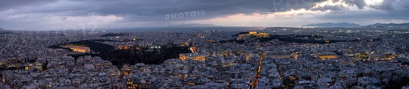 Panorama, view over the sea of houses of Athens, illuminated Parthenon temple on the Acropolis, dramatic cloudy sky, from Mount Lycabettus, Athens, Greece, Europe