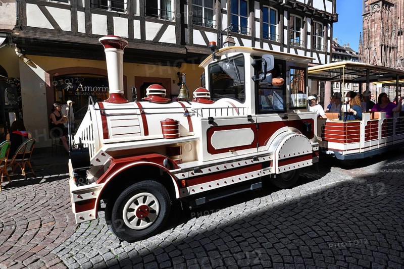 Strasbourg, France, September 2023: Small train called 'Petit Train' (Little Train) making guided tour with tourists through historic city center on sunny day, Europe
