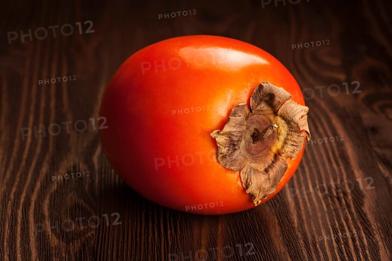 Fresh ripe persimmon on a wooden background