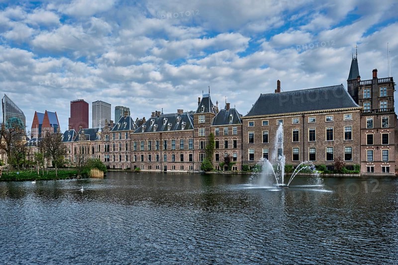 View of the Binnenhof House of Parliament and the Hofvijver lake with downtown skyscrapers in background. The Hague, Netherlands