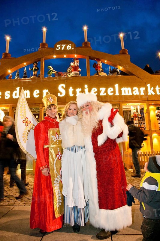 Angels of light, Stollen Girl Claudia Ruhmland and Father Christmas in front of the world's largest walk-in candle arch. Striezelmarkt, which has been organised since 1434, is the oldest Christmas market in Germany and takes place on the Altmarkt. The market was redesigned in 2009 and one of its special landmarks is the world's largest candle arch