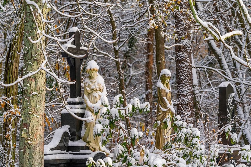 Graves with stone sculptures of mourning woman in the snow, Südwest-Kirchhof, historic cemetery in Stahnsdorf, Potsdam-Mittelmark, Brandenburg, Germany, Europe