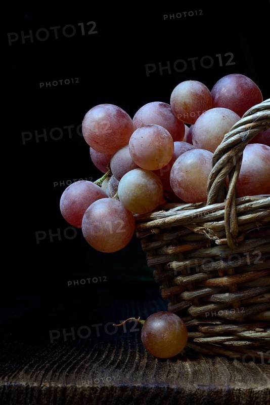 Red grape vine (Vitis vinifera) in baskets against a dark background