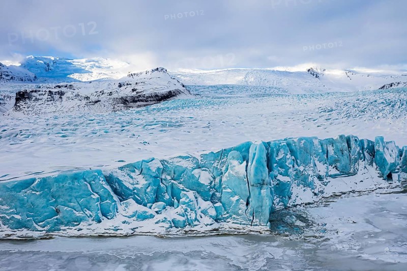 Snow-covered icebergs in the Fjallsarlon glacier lagoon, with the Öraefajökull glacier behind, drone shot, Sudurland, Iceland, Europe