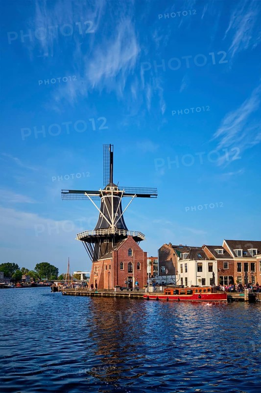 Harlem cityscape, landmark windmill De Adriaan on Spaarne river with boats. Harlem, Netherlands