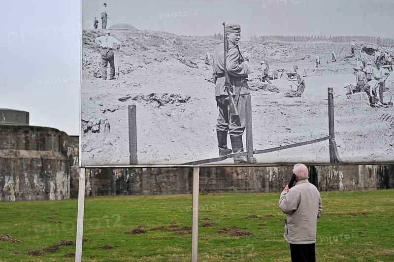 Visitors with audio guide looking at pictures of prisoners at Fort Breendonk, Belgium, Europe