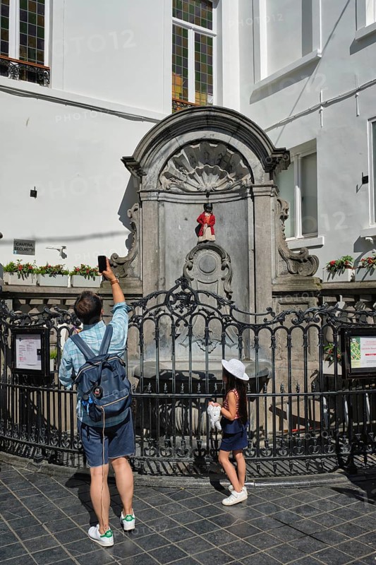 BRUSSELS, BELGIUM, MAY 31, 2018: Tourist taking pictures in front of famous tourist attraction of Brussels, dressed Manneken Pis statue fountain in Brussels. Bruxelles, Belgium, Europe