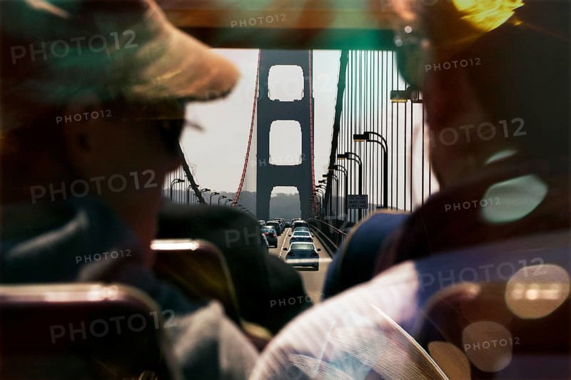 Passengers, tourists enjoying ride over the Golden Gate Bridge in a double-decker bus, coloured light reflections, San Francisco, California, USA, North America