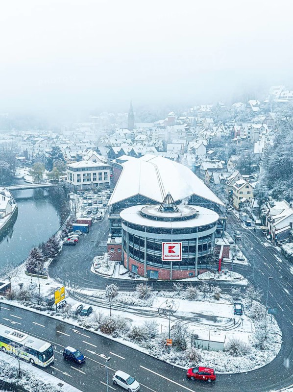 Aerial view of Kaufland, snow-covered shopping centre on a city street from a bird's eye view, Black Forest, Calw, Germany, Europe